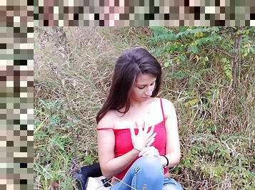 Spicy brunette takes off her jeans outdoors