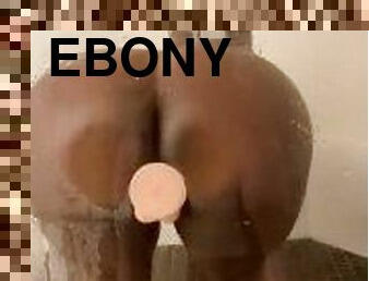 Ebony girl using white dildo in the shower