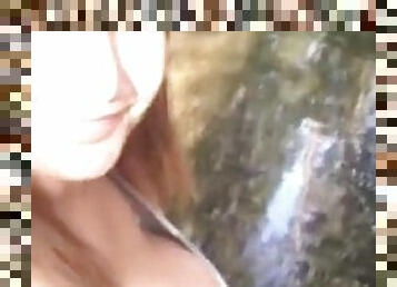 Woman with giant boobs wades in water and squeezes milk