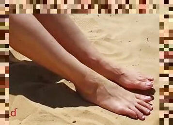 Cute girl takes of her sneakers and dirty socks while hiking in the desert