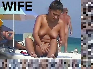 Hot woman shows off her bushy muff on a nudist beach