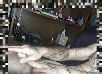 Tattooed man jacking off to the sound of her masturbating.